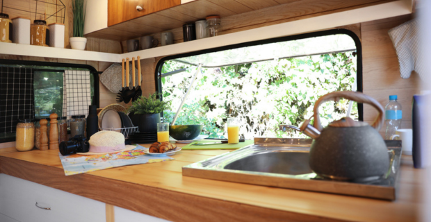 Stylish kitchen interior with different accessories and utensils in modern trailer. 
